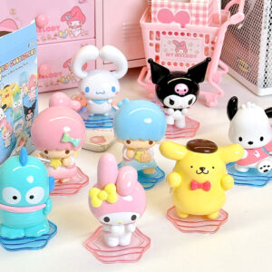Colorful Sanrio character figurines displayed on a tabletop with pastel décor and miniature shopping accessories.