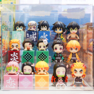 Display case filled with anime-style collectible figurines inspired by Demon Slayer characters arranged on colorful blocks.
